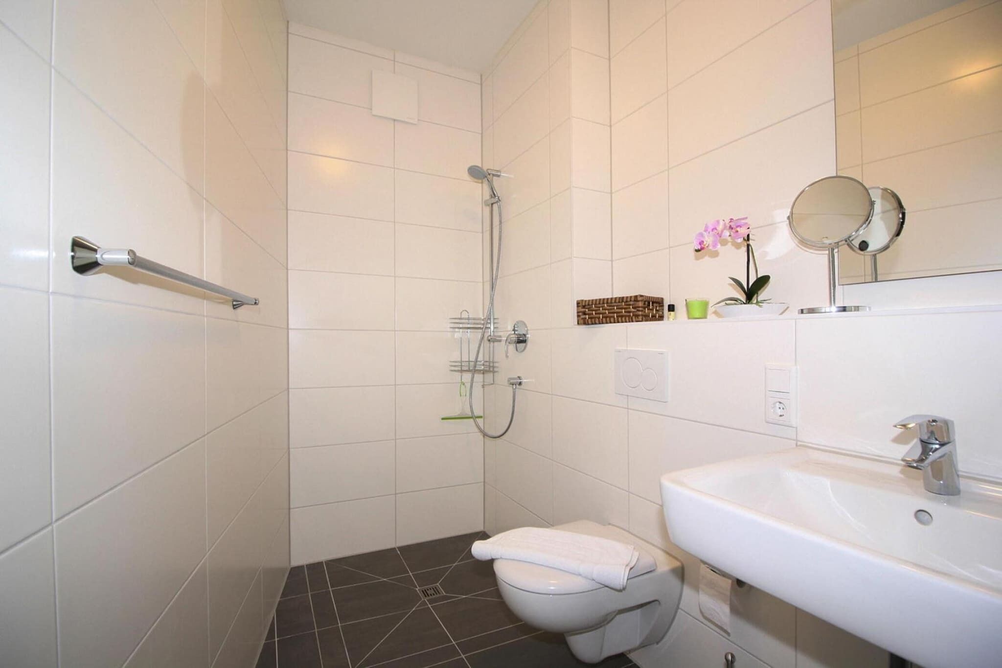 Un bagno con servizi igienici, lavandino, doccia e portasciuga.