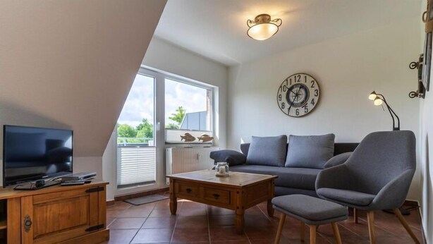 A modern living room with a TV, sofa, and coffee table.