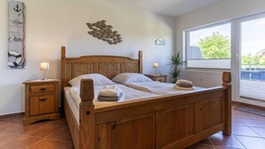 A double wooden bed with a headboard, two bedside tables, and a nightstand.