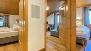Une pièce chaleureuse avec un plancher et des murs en bois, un lit, un canapé et un coin repas.