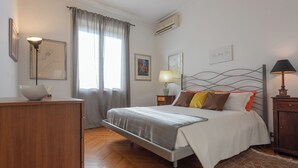 A bedroom with a bed, bedside tables, a dresser, and artwork on the walls. - Casa Torricelli in zona Crocetta by Wonderful Italy (Turin)