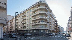 A multi-story residential building with balconies, a street in front, and parked cars. - Casa Torricelli in zona Crocetta by Wonderful Italy (Turin)