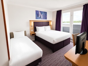 A hotel room with two beds, a TV, a painting, and a window with curtains. - Willen Lodge (Milton Keynes)