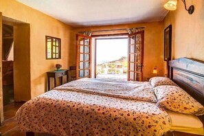 A bedroom with a bed, a nightstand, a window, and a view of the outside. - Apartment in El Tanque with bubble bath (El Tanque)
