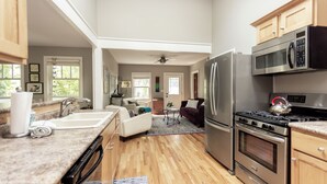 A kitchen with a refrigerator, stove, microwave, and wooden cabinets.