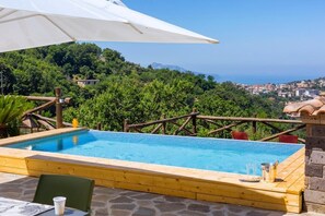 A wooden pool with a view of a coastal town and greenery. - VILLA ALESSANDRA , SANTA AGATA DEI DUE GOLFI (Sant'Agata Sui Due Golfi)