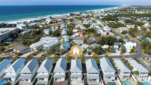 Zona residencial costera con casas, una playa y cielo despejado.