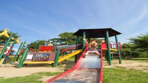 A playground with a red slide and various play structures.