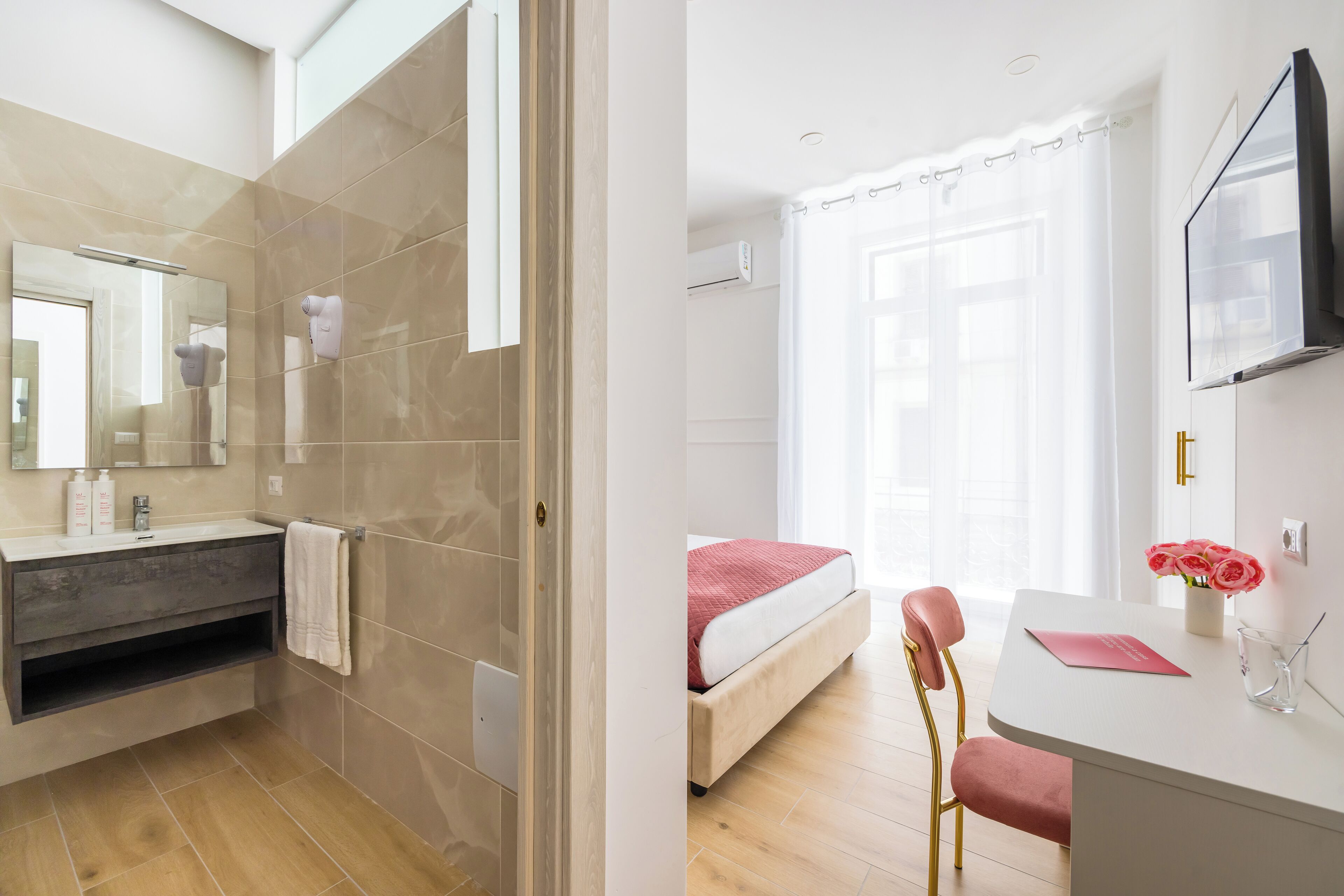 Ein modernes Badezimmer mit Dusche, Waschtisch inklusive Spiegel und einem Handtuch an der Wand.