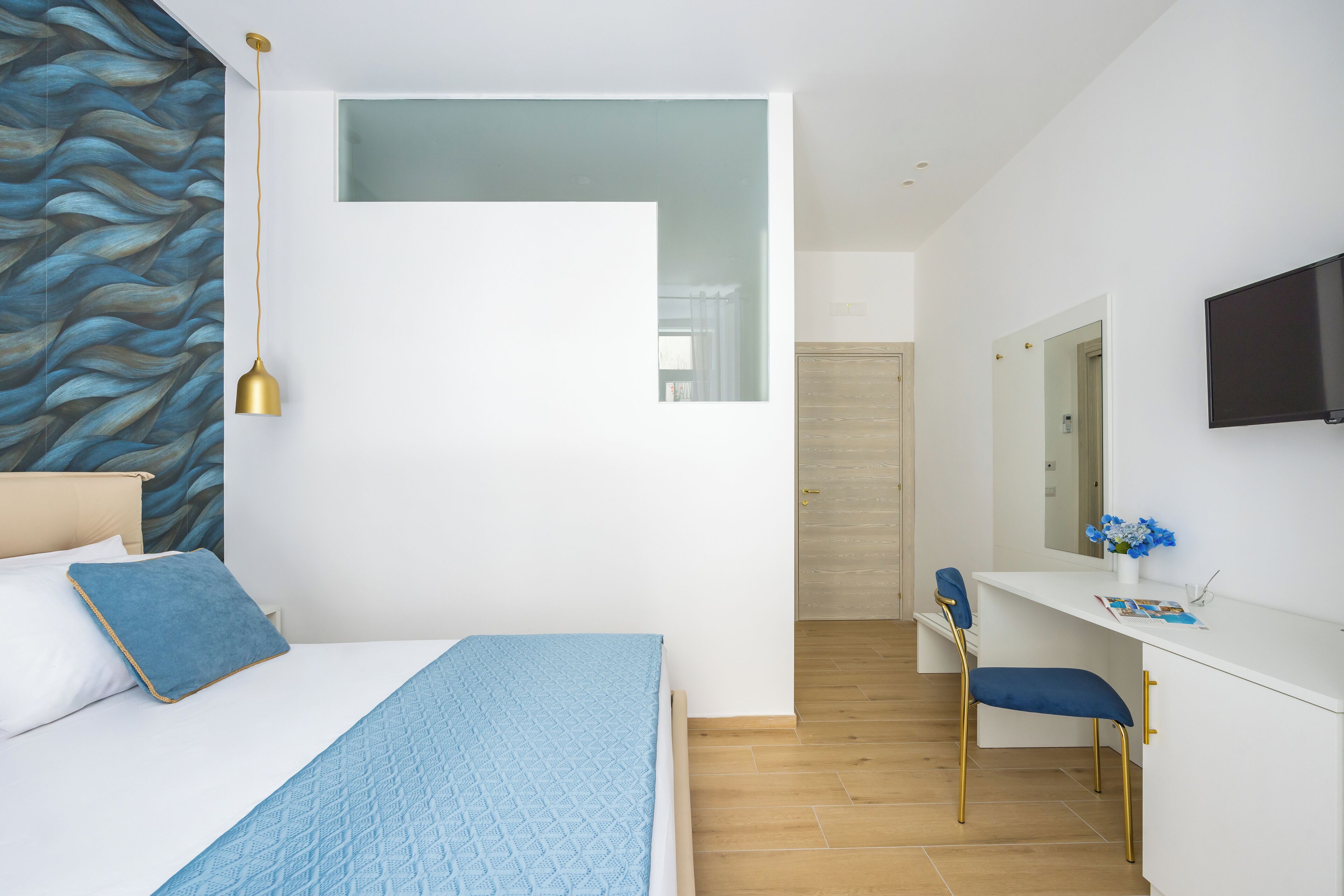A modern bedroom with a bed, a desk, and a chair.