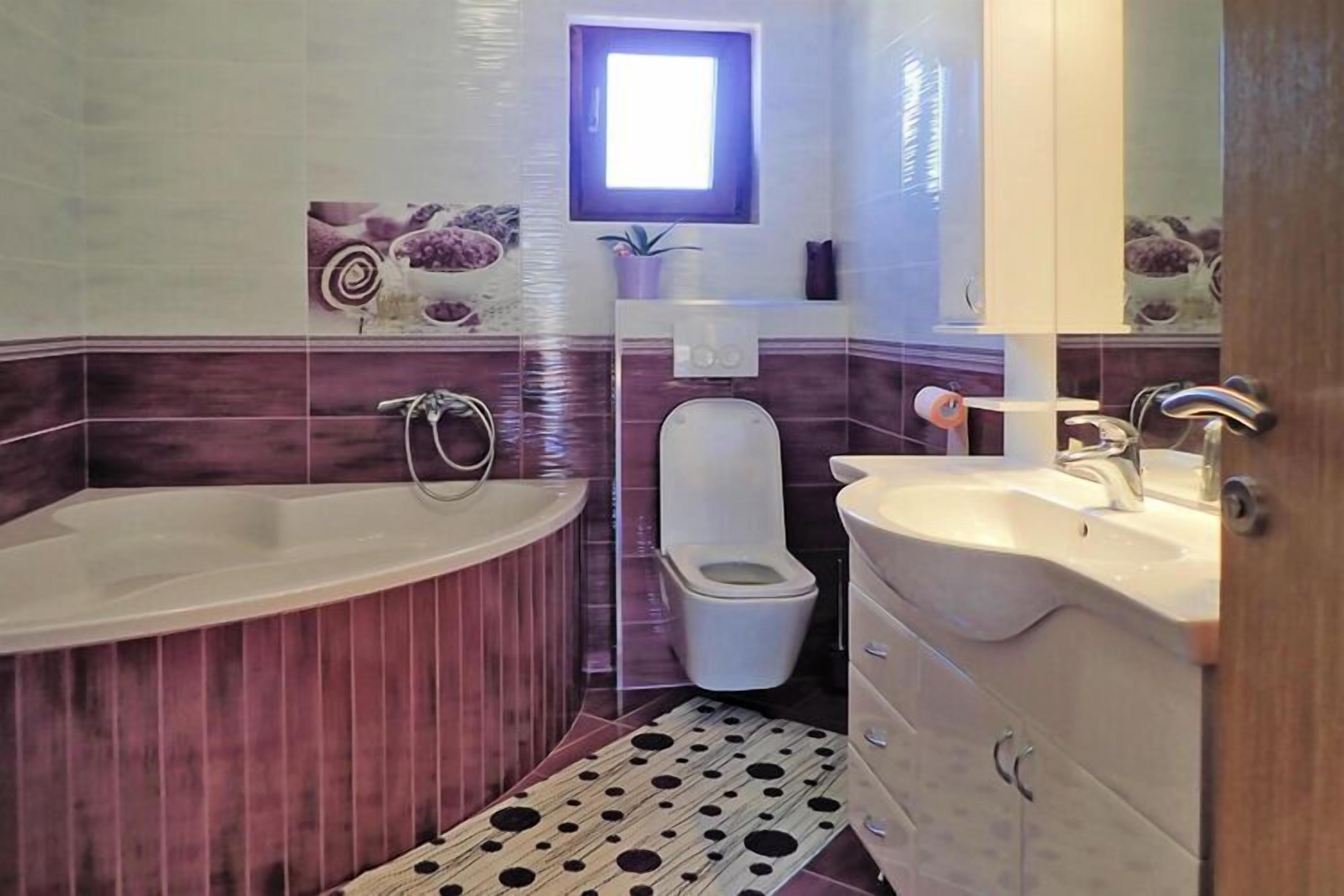 Une salle de bain avec une baignoire sur pieds, des toilettes et un meuble-lavabo avec un miroir.