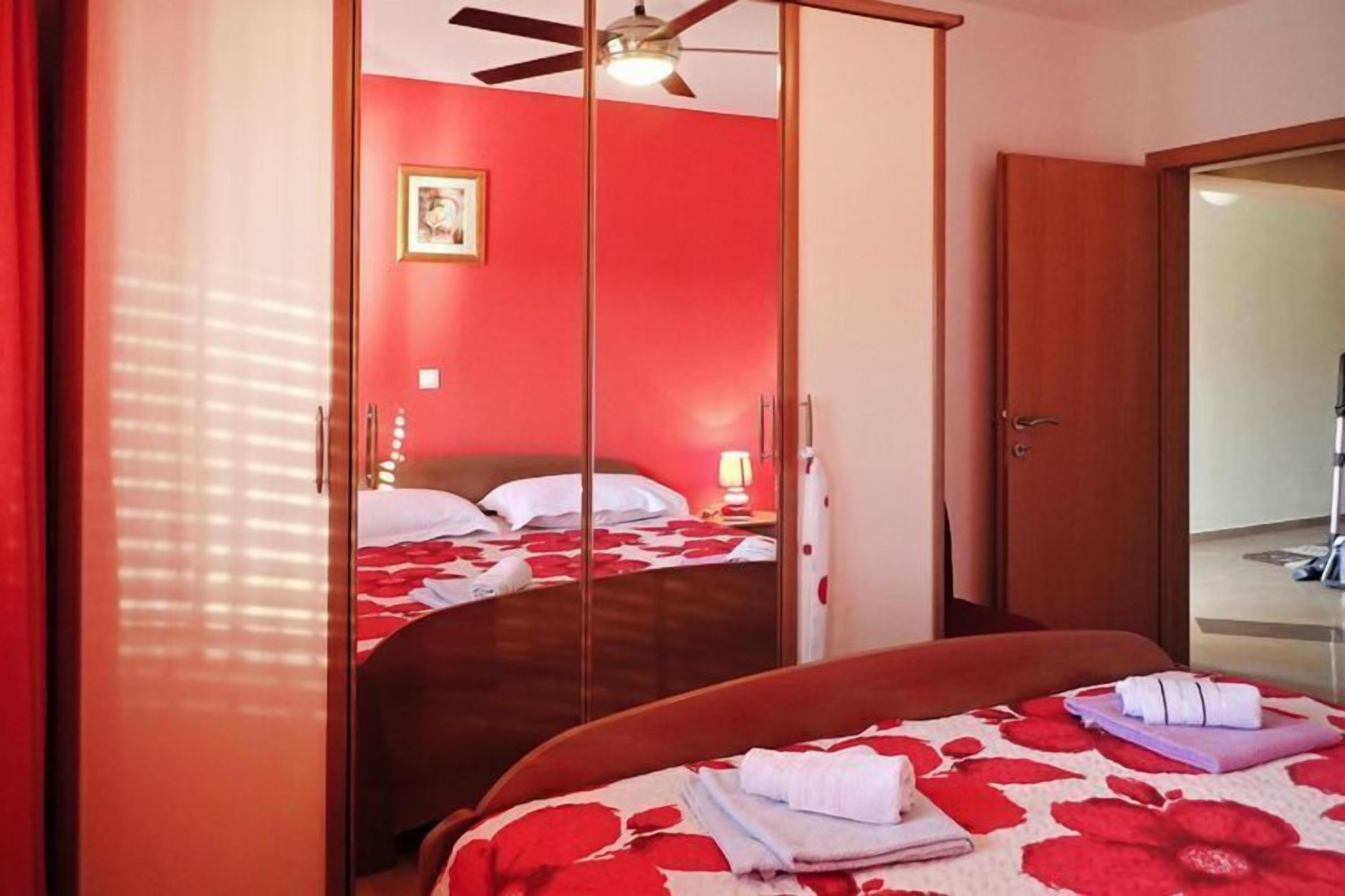 A hotel room with a bed, a wardrobe, and a ceiling fan.