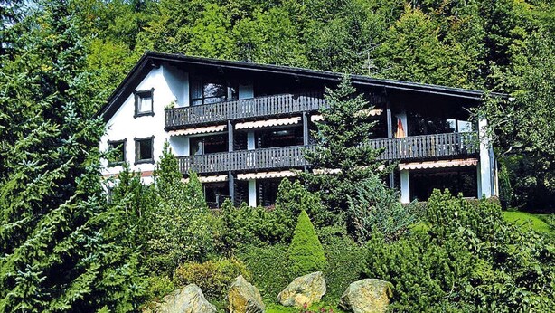 A multi-story building with balconies, surrounded by lush greenery and rocks. - Ferienwohnung im Haus Schiefertal, Wieda (Wieda)