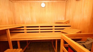 A sauna with wooden benches and a red basket. - Ferienwohnung im Haus Schiefertal, Wieda (Wieda)