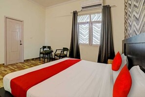 Una habitación de hotel con una cama, un escritorio y una silla.