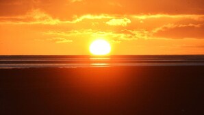 A sunset over the ocean with a clear sky.