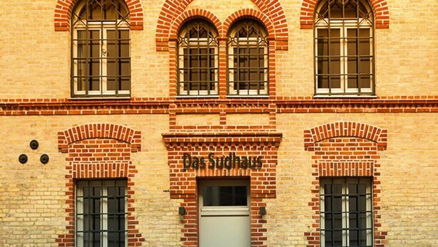 A building with three arched windows and a sign reading "Das Sudhaus". - Appartements im Sudhaus in Schwerin (Schwerin)