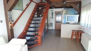 A staircase leading to a kitchen area with a television and stools. - Holiday Home Sulomino with Private Beach (Sulomino)