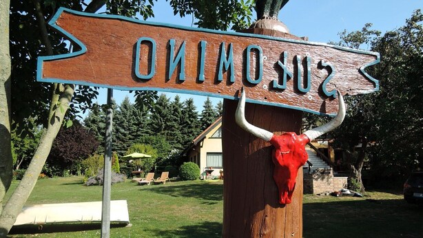 A wooden sign with the name 'SUSUMO' and a red bull's head decoration. - Holiday Home Sulomino with Private Beach (Sulomino)