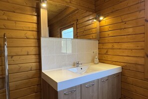 A wooden cabin bathroom with a white sink, a mirror, and a shower. - Blockhaus, Bad Sachsa (Bad Sachsa)