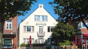 A traditional building with a sign reading "GUD KOOB" and a balcony.