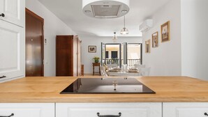 A modern kitchen with a wooden countertop, white cabinets, and a built-in stove. - Classic Urban Flat in Malaga City Center - Mal05 (Málaga)
