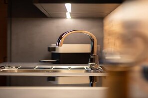 A modern kitchen with a stainless steel sink and a curved faucet.