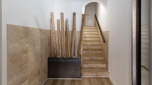 A staircase with a handrail, a wall with a door at the top, and a black object on the floor. - Unik Vacation Alt Camp (Puigpelat)