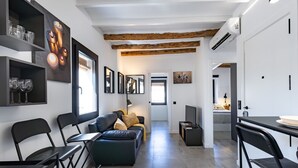 A modern living space with a sofa, dining area, and kitchen. - Unik Vacation Alt Camp (Puigpelat)