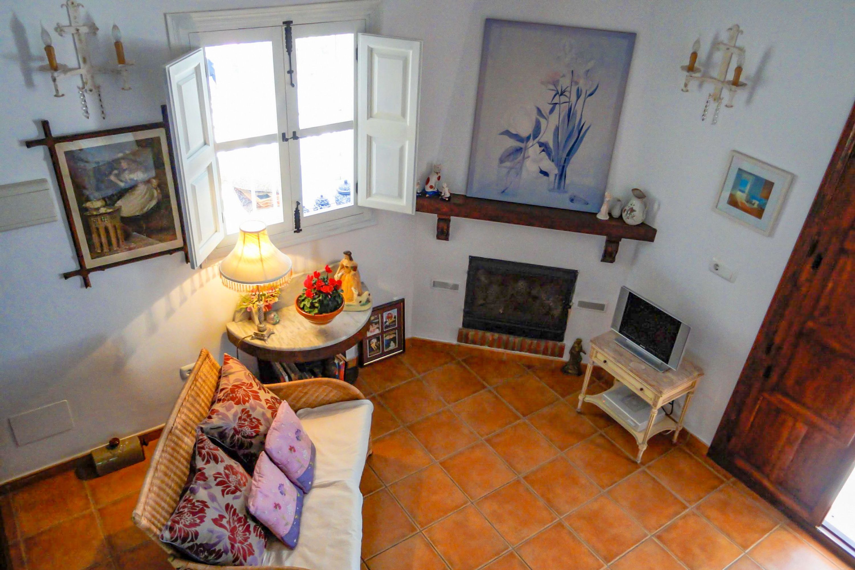 Un salon avec un canapé, une table avec une lampe, une cheminée et un téléviseur.