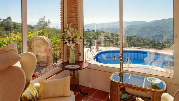 Un balcon avec vue sur une piscine et des montagnes.