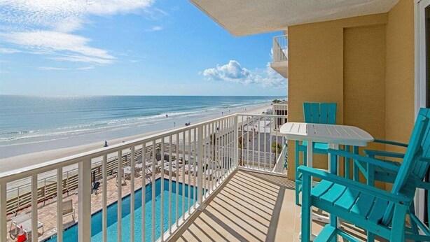Un balcon avec vue sur la plage et la piscine.