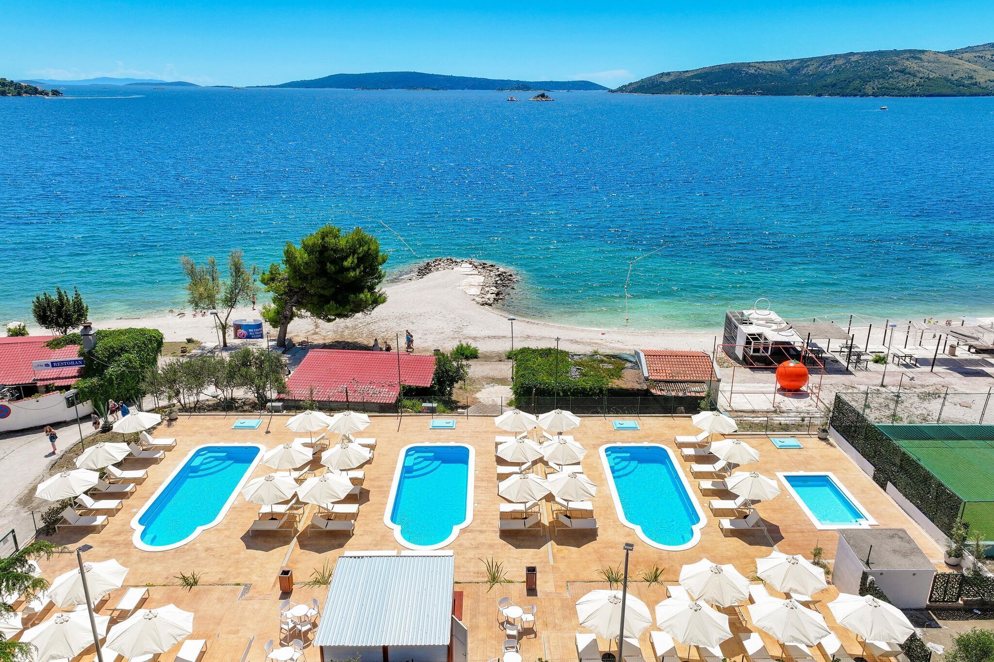 A resort with multiple swimming pools, beach access, and a view of the sea.