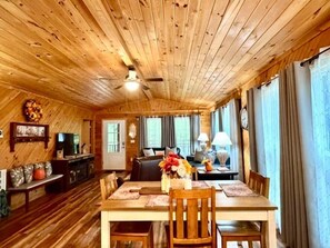 A wooden interior with a dining area, kitchen, and living space. - Escape to the serene Diamond Creek Cabin (Bryson City)