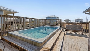 Un jacuzzi en una terraza de madera, rodeado por una valla de madera.