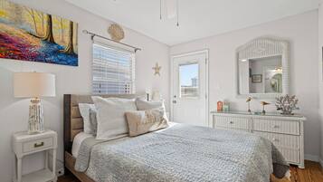 Une chambre à coucher avec un lit, une table de chevet, une lampe et un grand tableau au mur.