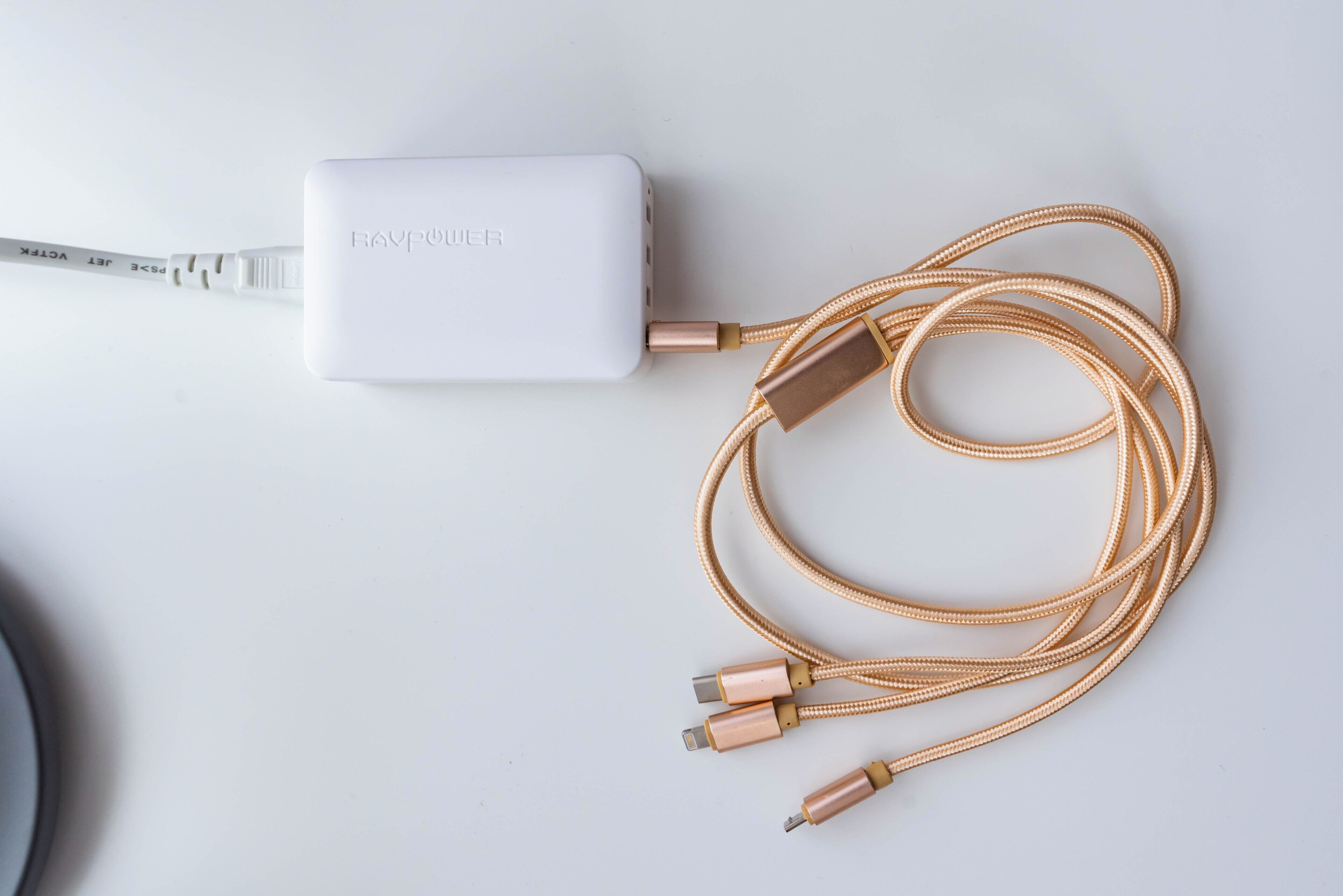 A white power adapter with a braided cable and two USB connectors.