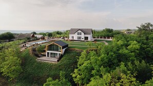 A modern house with a large lawn, a swimming pool, and a view of the countryside. - Purcari Retreat (Purcari)