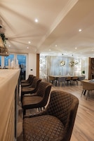A modern dining area with a long counter and multiple seating options.