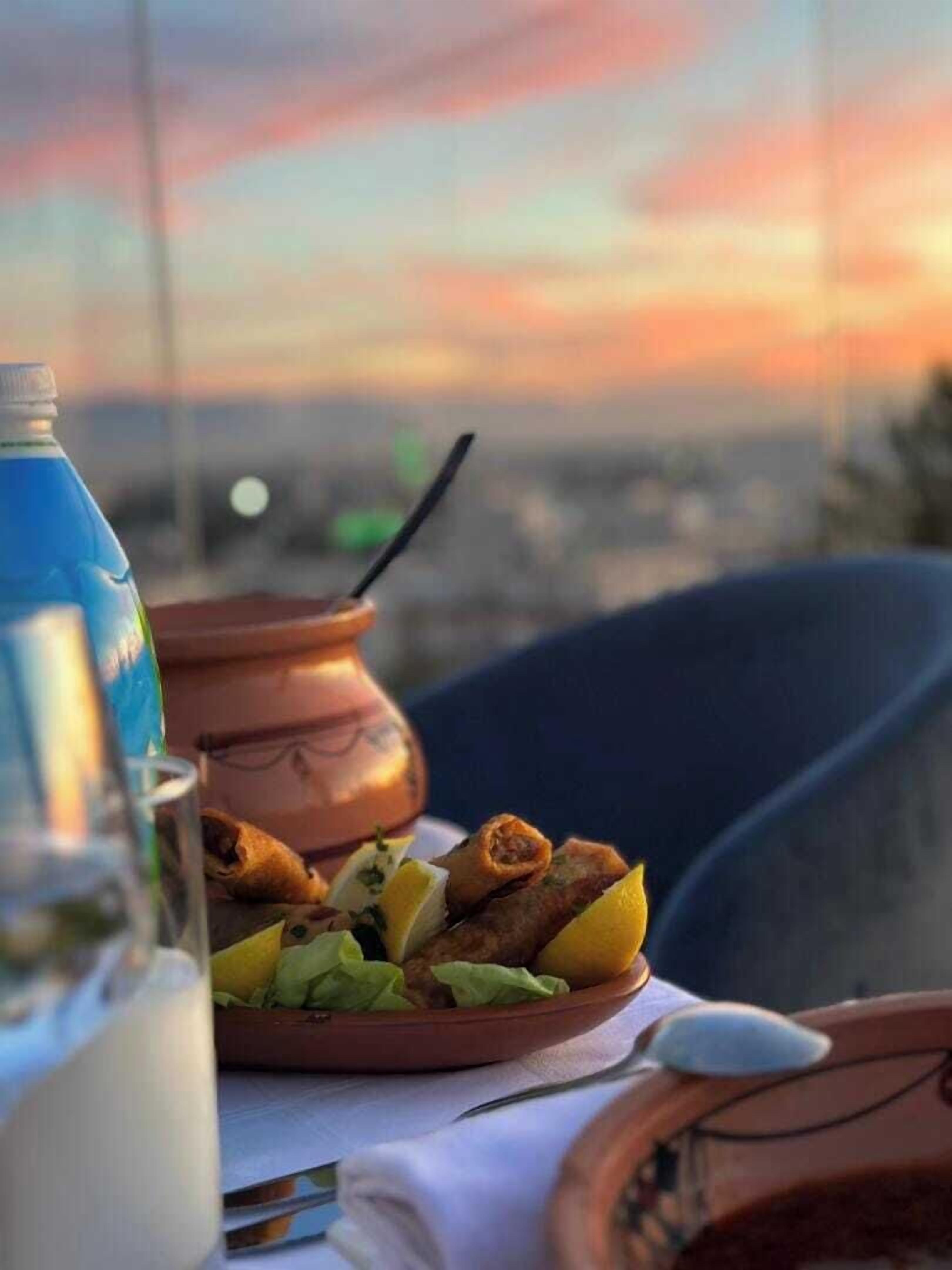 Une table avec une assiette de nourriture, une bouteille et un verre.