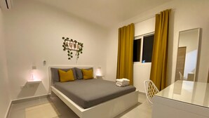 Una camera da letto moderna con un letto, lampade da comodino, uno specchio e una finestra con tende.