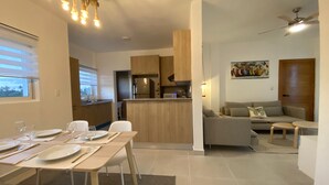 Un soggiorno moderno con zona pranzo, cucina e area salotto.