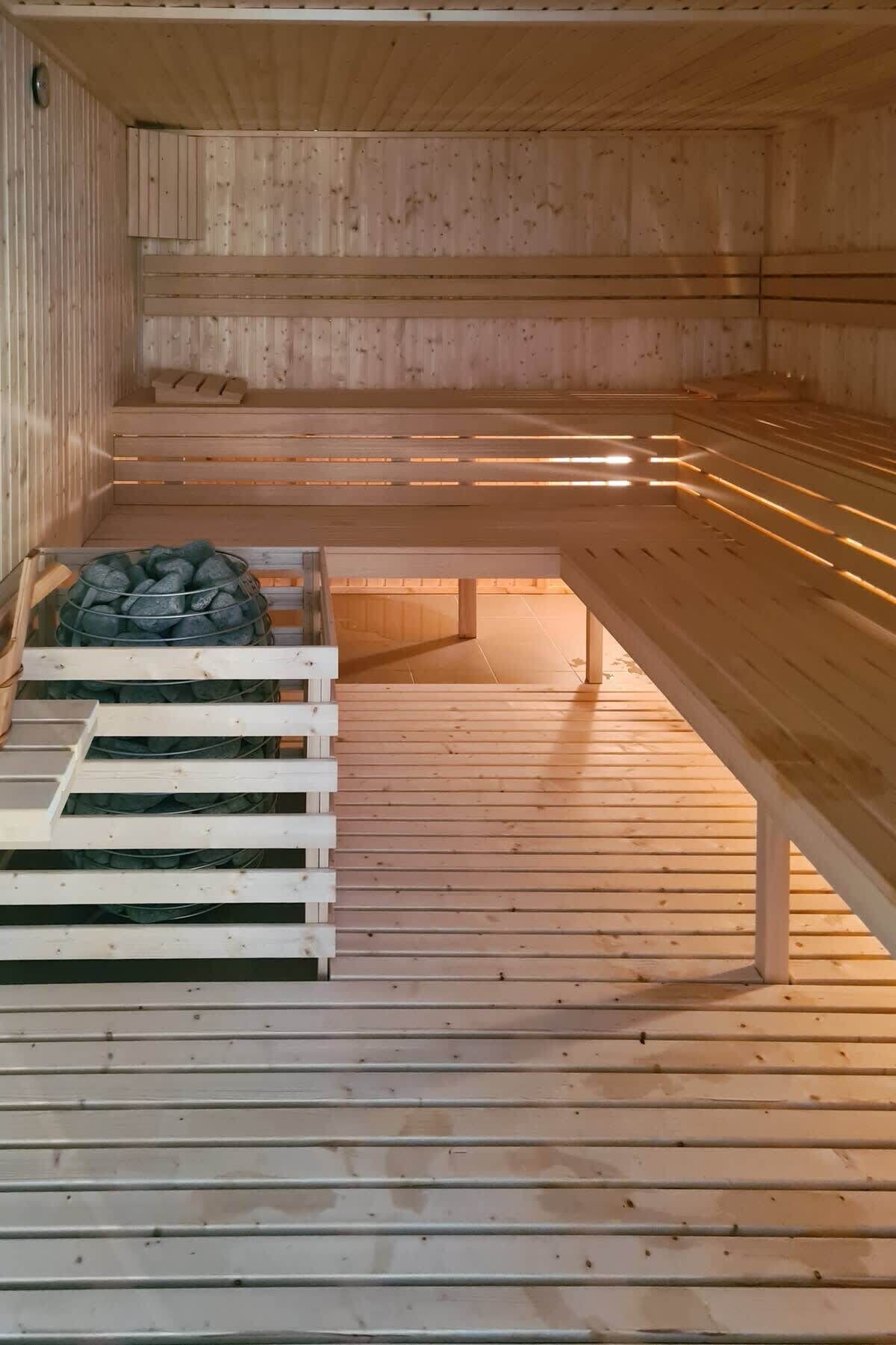 A sauna with wooden benches and a stone bench area.