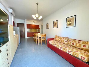 Un espacio habitable pequeño con kitchenette, comedor y sofá.