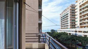 Ein Balkon mit Blick auf eine belebte Straße und Gebäude.