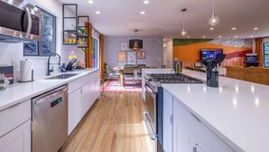 Una cucina moderna con mobili bianchi, elettrodomestici in acciaio inossidabile e un'isola centrale.
