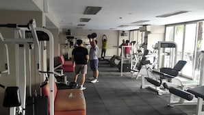 A gym with various exercise equipment, including weight machines and benches. - Hotel Riau (Bekasi)