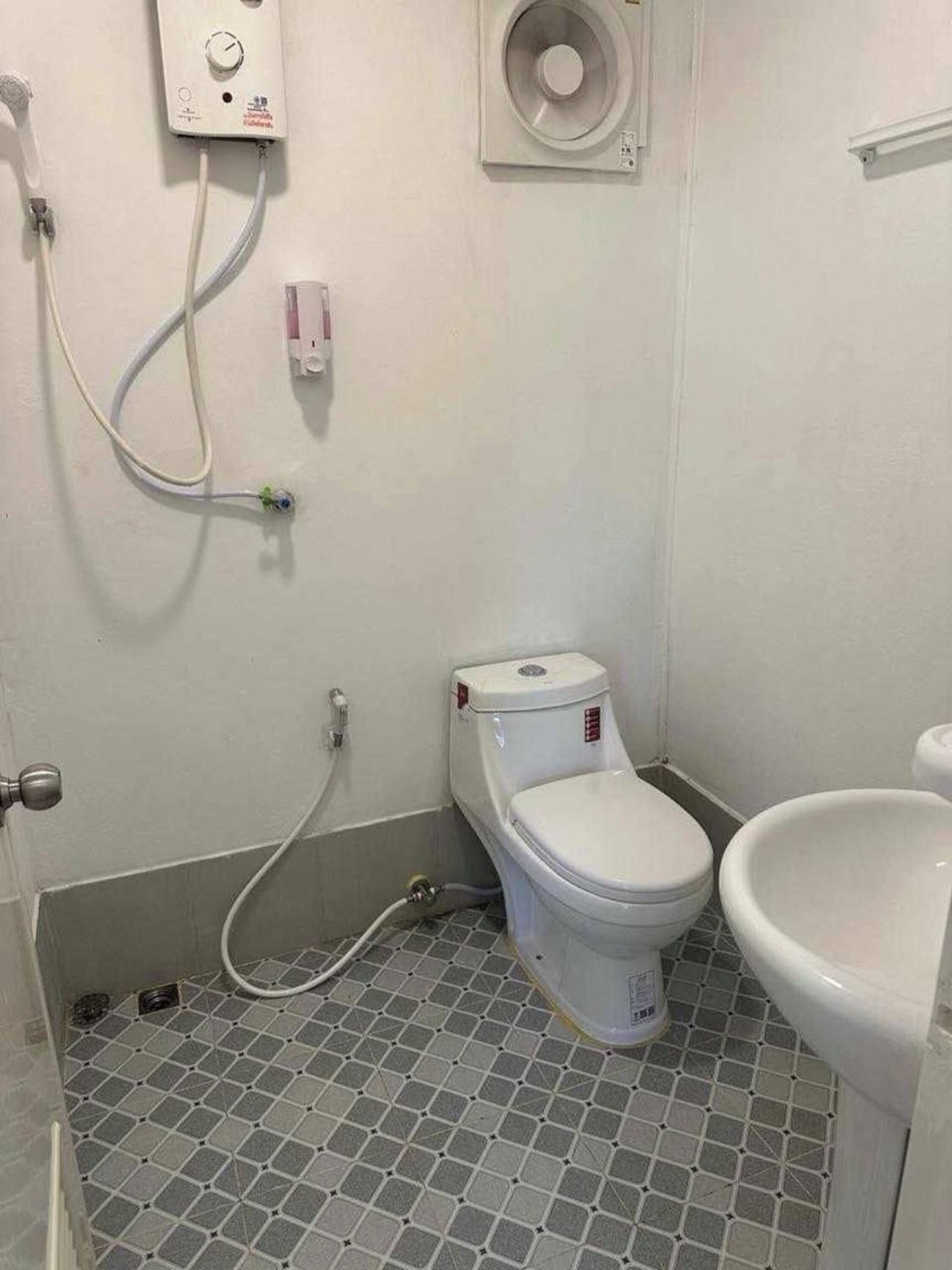 A bathroom with a toilet, bidet, and a shower area.