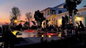 A waterfront area with a pool, outdoor seating, and buildings in the background. - Khao Chi Chan Resort (Sattahip)
