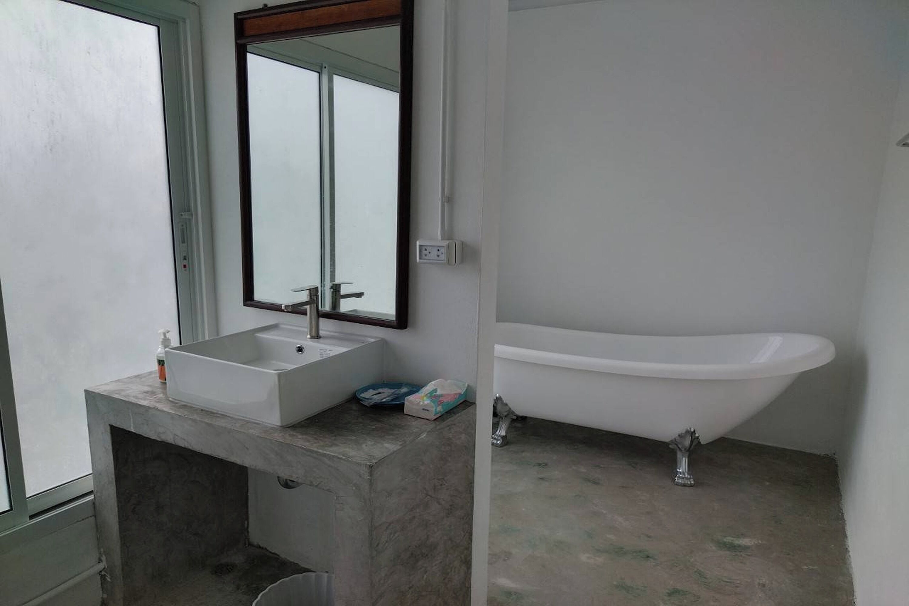 A bathroom with a white sink, a mirror, and a white bathtub.